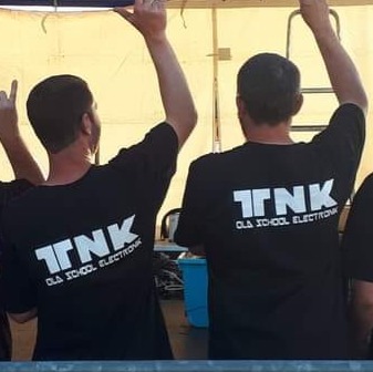 2 membres de l'association Tek N' Kor de dos avec le logo de l'association sur leur t-shirt.